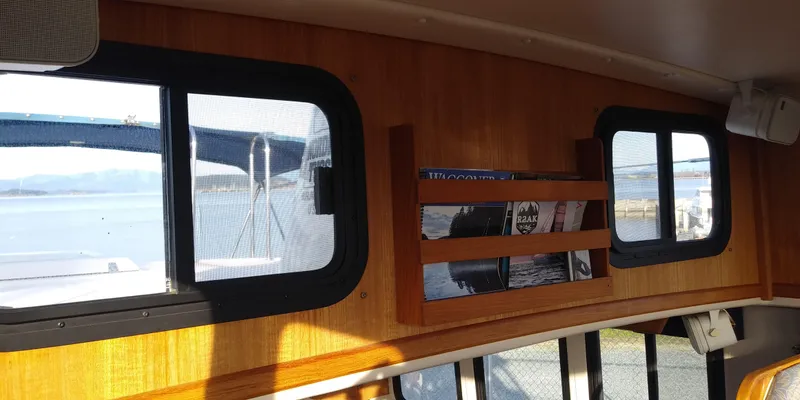 Slide: The Image of Interior of a 2001 Nordic Tug 32 with wooden walls and windows overlooking the water. - 37