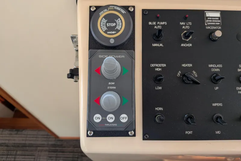Slide: The Image of Control panel of a 2001 Nordic Tug 32, featuring side-power thrusters and various switches. - 36