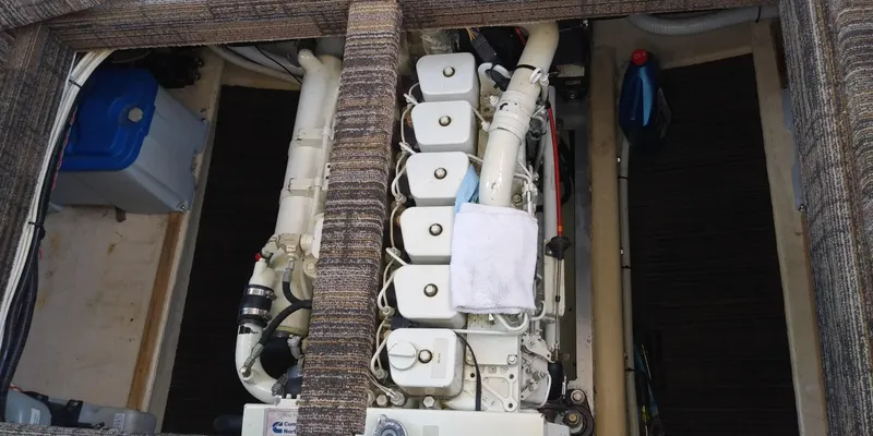 Slide: The Image of An engine compartment with a large white engine and various hoses and cables. - 50