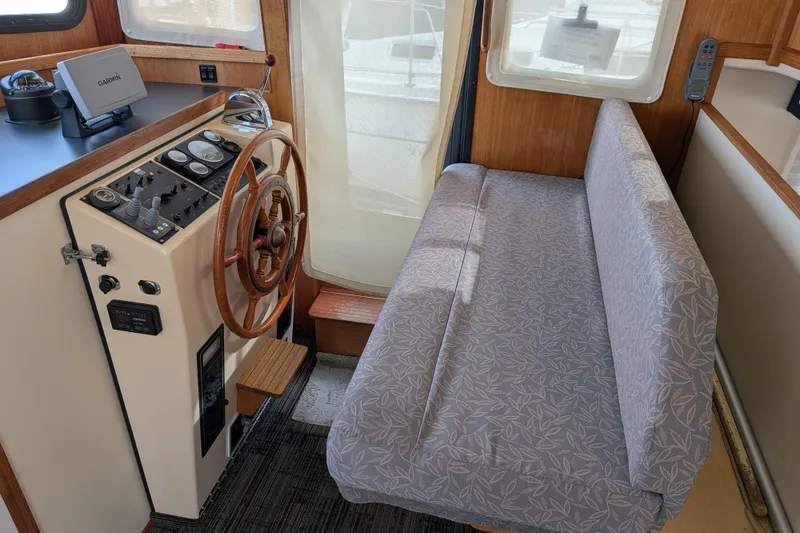 Slide: The Image of Interior of a 2001 Nordic Tug 32, featuring helm station and cushioned seating. - 45