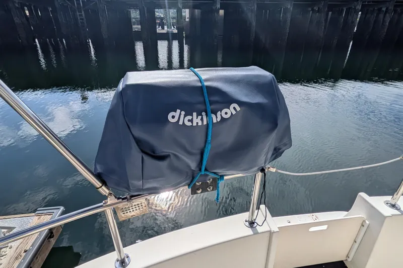 Slide: The Image of Covered grill on a 2001 Nordic Tug 32 boat, docked by calm water. - 73