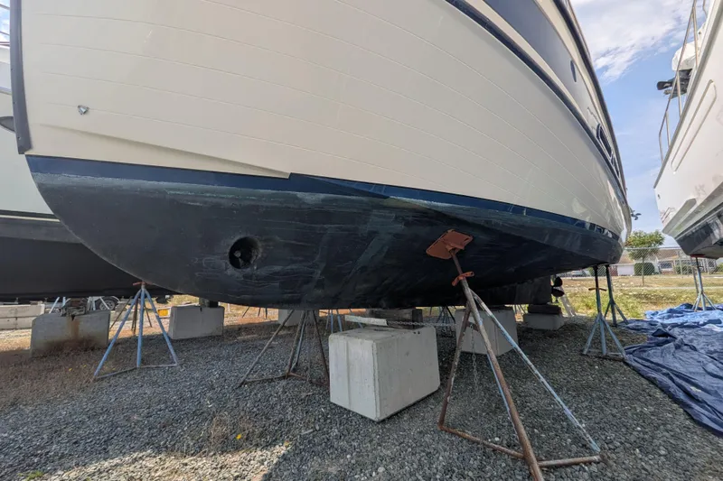 Slide: The Image of 2001 Nordic Tug 32 boat on stands, hull view, outdoor storage. - 77