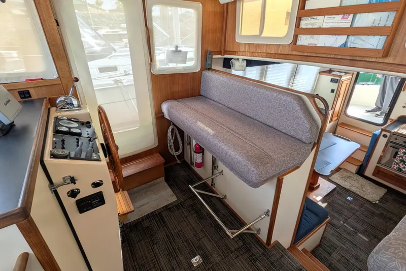 Slide: The Image of Interior of a 2001 Nordic Tug 32 boat, featuring helm controls and seating area. - 44