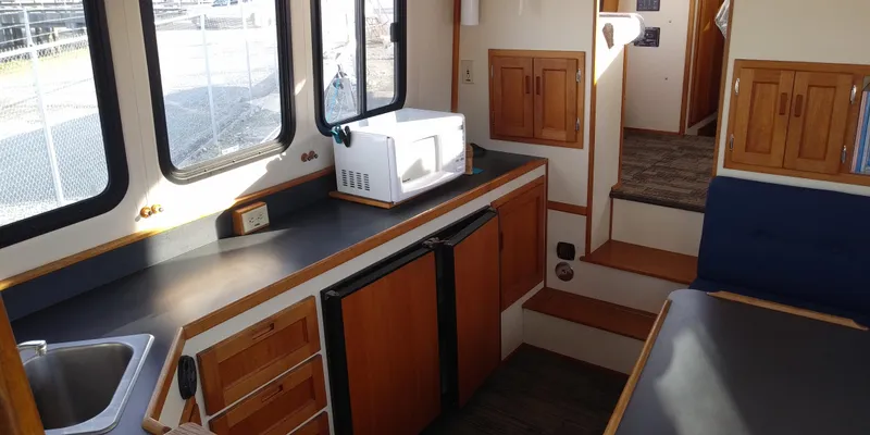Slide: The Image of Interior of a 2001 Nordic Tug 32 featuring a kitchen, microwave, and seating area. - 19
