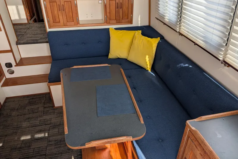 Slide: The Image of Interior of a 2001 Nordic Tug 32 with blue seating and yellow cushions. - 21