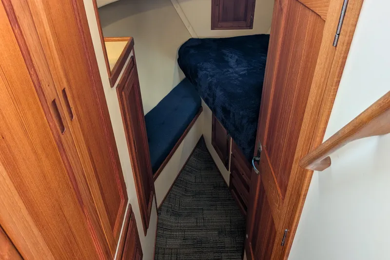 Slide: The Image of Cozy cabin interior of 2001 Nordic Tug 32 with wooden finishes and plush bedding. - 51
