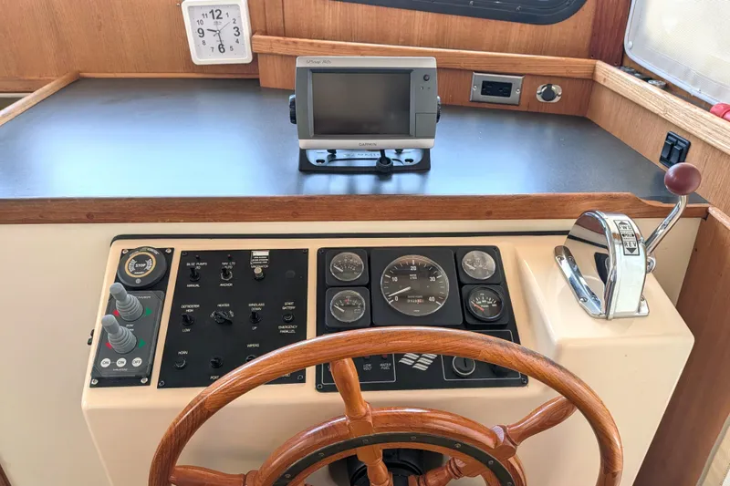 Slide: The Image of 2001 Nordic Tug 32 helm with wooden wheel, control panel, and navigation equipment. - 34