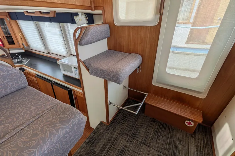 Slide: The Image of Interior of a 2001 Nordic Tug 32, featuring a cozy seating area and kitchenette. - 48