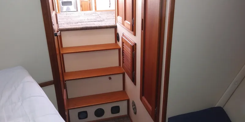 Slide: The Image of Wooden stairs in a boat cabin with carpeted floor and wooden doors. - 45
