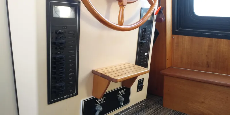Slide: The Image of Helm of a 2001 Nordic Tug 32 with a wooden wheel and instrument panels. - 35