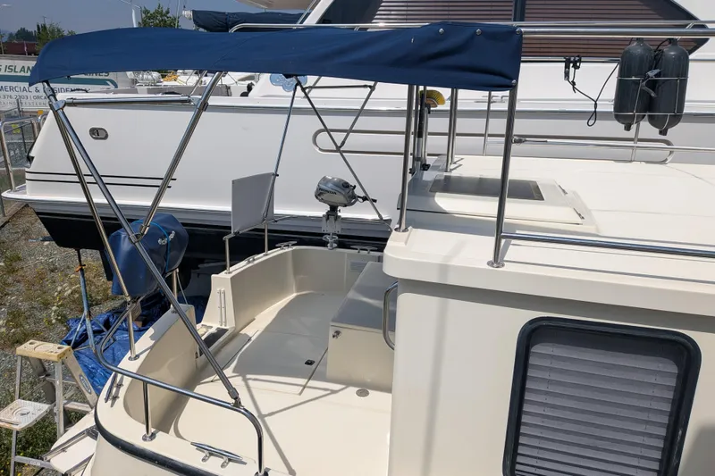 Slide: The Image of 2001 Nordic Tug 32 boat with blue canopy and deck view. - 9