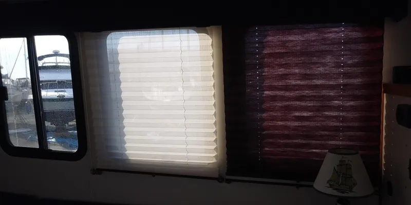 Slide: The Image of Interior view of a boat with windows and blinds, partially open, overlooking another boat. - 24