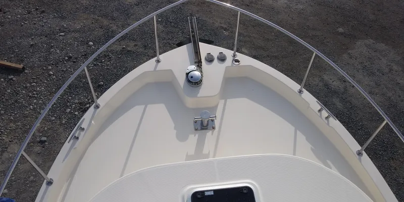 Slide: The Image of Bow view of the 2001 Nordic Tug 32 with a clean deck and stainless steel railing. - 12