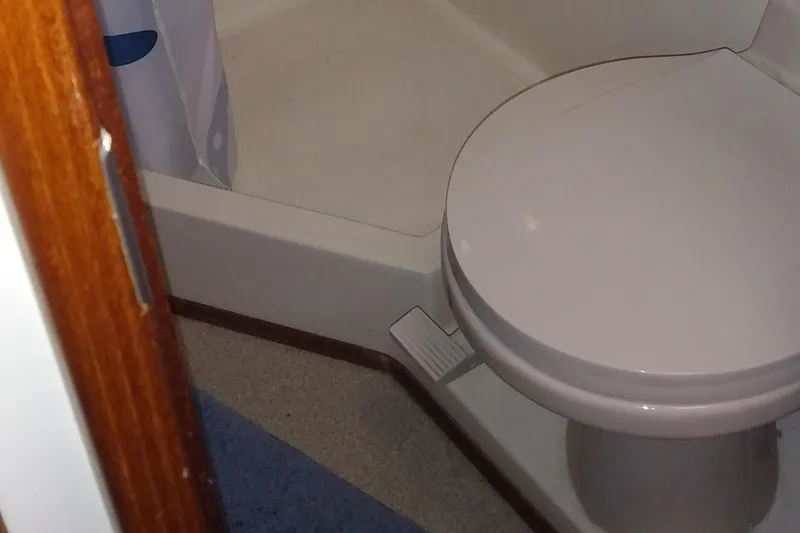 Slide: The Image of The image shows a toilet in a boat bathroom with a shower stall. - 44