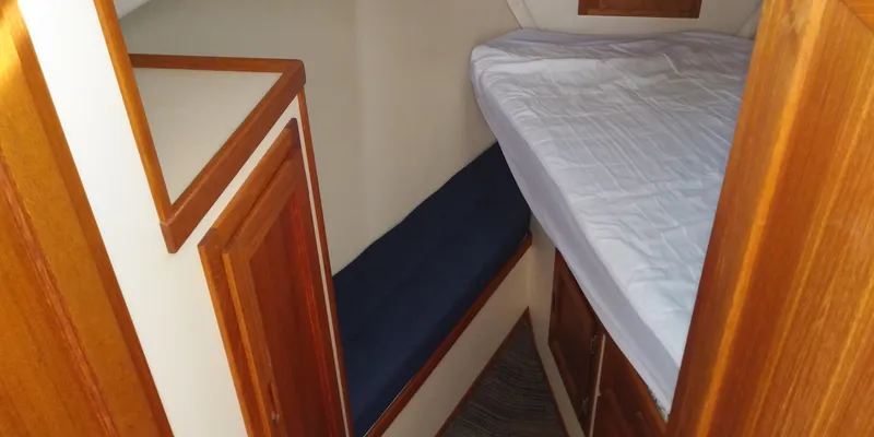 Slide: The Image of Cabin of a 2001 Nordic Tug 32 with wood paneling, bed, and bench. - 41