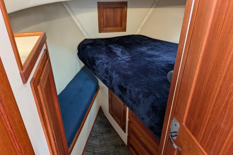 Slide: The Image of Cozy cabin interior of 2001 Nordic Tug 32 with wooden finishes and plush bedding. - 52