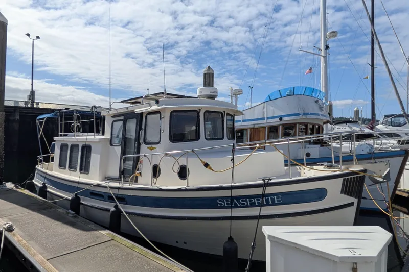 Slide: The Image of 2001 Nordic Tug 32 "Seasprite" docked at marina under blue sky. - 2