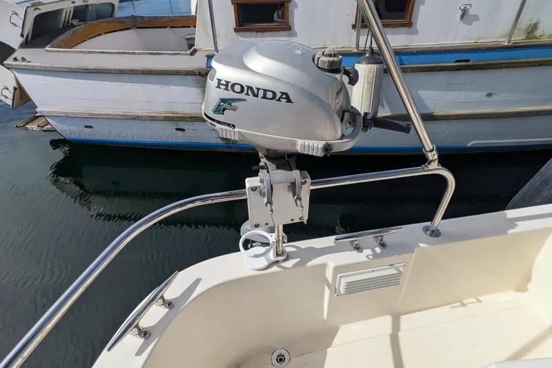 Slide: The Image of Honda outboard motor on a 2001 Nordic Tug 32, docked beside another boat. - 74