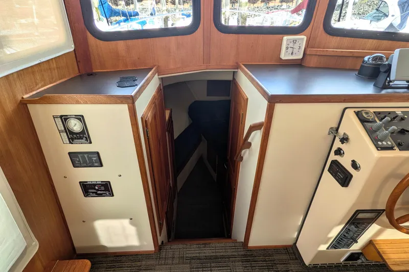 Slide: The Image of Interior of a 2001 Nordic Tug 32, featuring control panels and a cabin entrance. - 49
