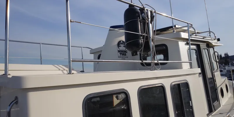 Slide: The Image of A 2001 Nordic Tug 32 with a sturdy structure and railing. - 17
