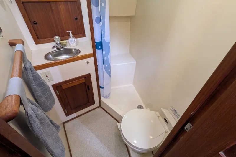 Slide: The Image of Bathroom interior of a 2001 Nordic Tug 32, featuring sink, toilet, and shower. - 56