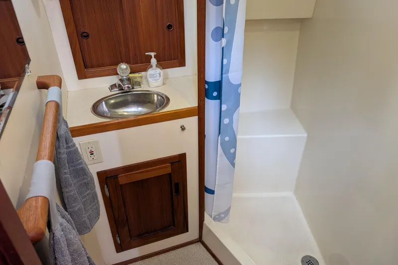 Slide: The Image of Bathroom interior of a 2001 Nordic Tug 32, featuring sink and shower area. - 54