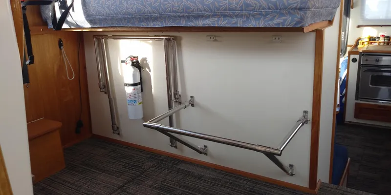 Slide: The Image of Interior of a 2001 Nordic Tug 32 with a foldable table and fire extinguisher. - 34