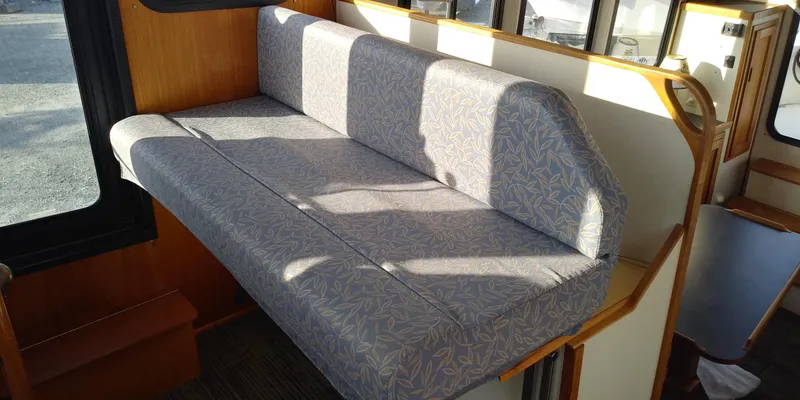 Slide: The Image of Interior of a 2001 Nordic Tug 32 with a cushioned seating area. - 33