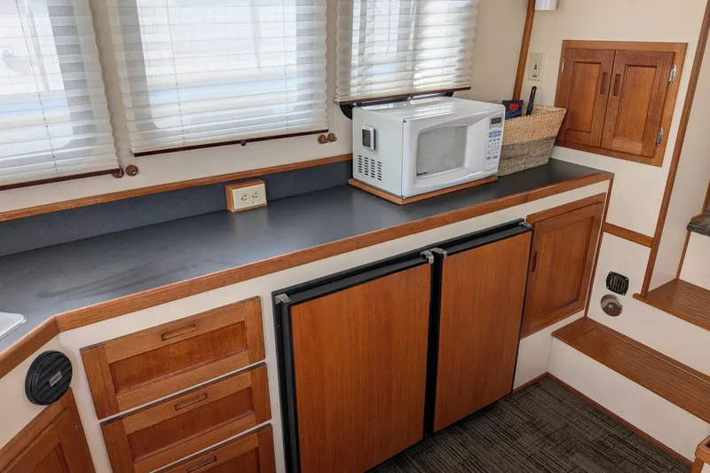 Slide: The Image of 2001 Nordic Tug 32 interior kitchen with microwave, wooden cabinets, and countertop. - 25