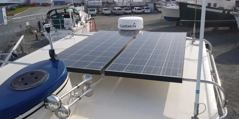 Slide: The Image of The image shows a 2001 Nordic Tug 32 boat with solar panels on the roof. - 10