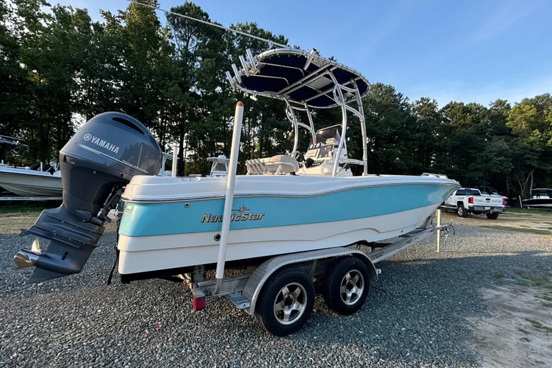 Slide: The Image of 2018 NauticStar 211 Coastal boat with Yamaha engine on trailer, parked outdoors. - 3