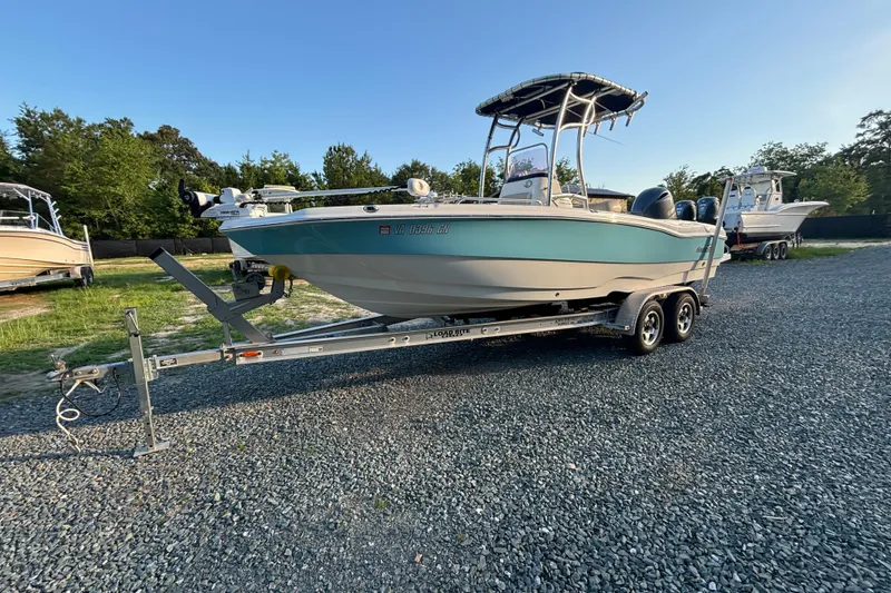 The Image of 2018 NauticStar 211 Coastal boat on trailer, parked outdoors on gravel. - 0