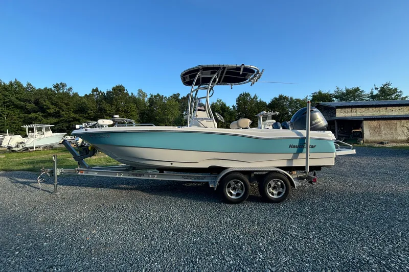 Slide: The Image of 2018 NauticStar 211 Coastal boat on trailer, parked outdoors under clear blue sky. - 1