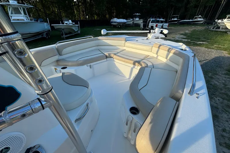 Slide: The Image of 2018 NauticStar 211 Coastal boat interior with beige seating and cup holders. - 10