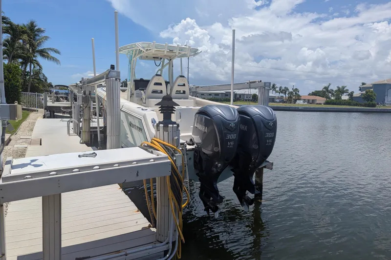 Slide: The Image of 2023 Sailfish 290 CC boat docked with dual Yamaha 300 V6 engines. - 3