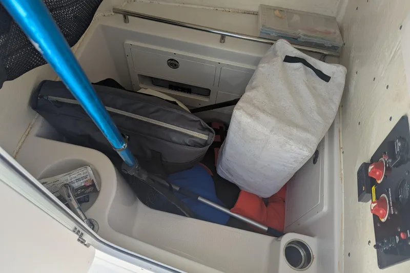 Slide: The Image of Storage compartment in a 2023 Sailfish 290 CC boat, containing gear and equipment. - 14
