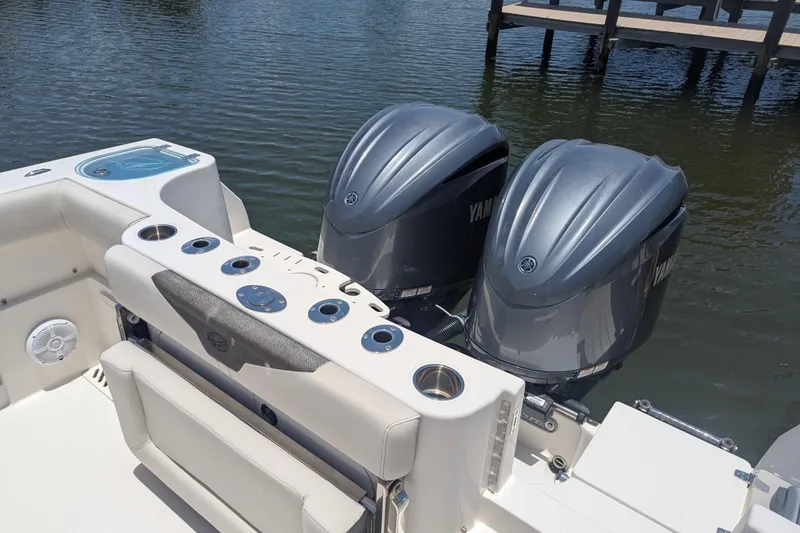 Slide: The Image of 2023 Sailfish 290 CC boat with dual Yamaha outboard engines on water. - 12