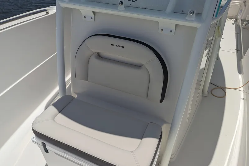 Slide: The Image of 2023 Sailfish 290 CC boat seat with white upholstery and storage compartment. - 5
