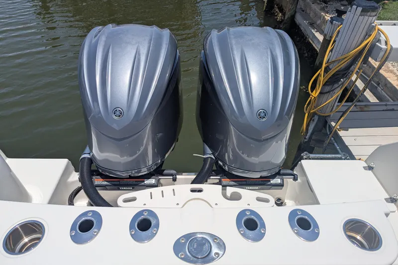 Slide: The Image of Twin Yamaha outboard engines on a 2023 Sailfish 290 CC boat docked by the water. - 11