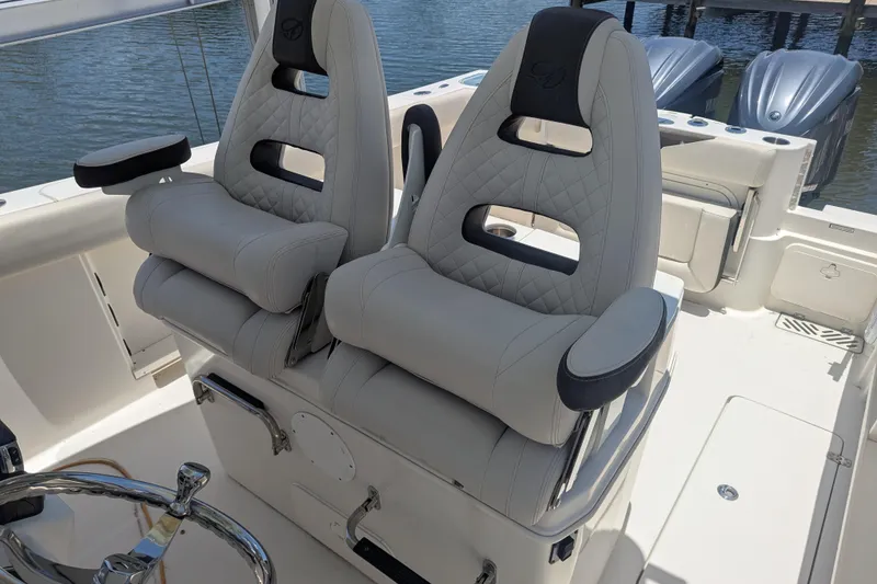 Slide: The Image of 2023 Sailfish 290 CC boat with luxurious dual captain's chairs and sleek design. - 8