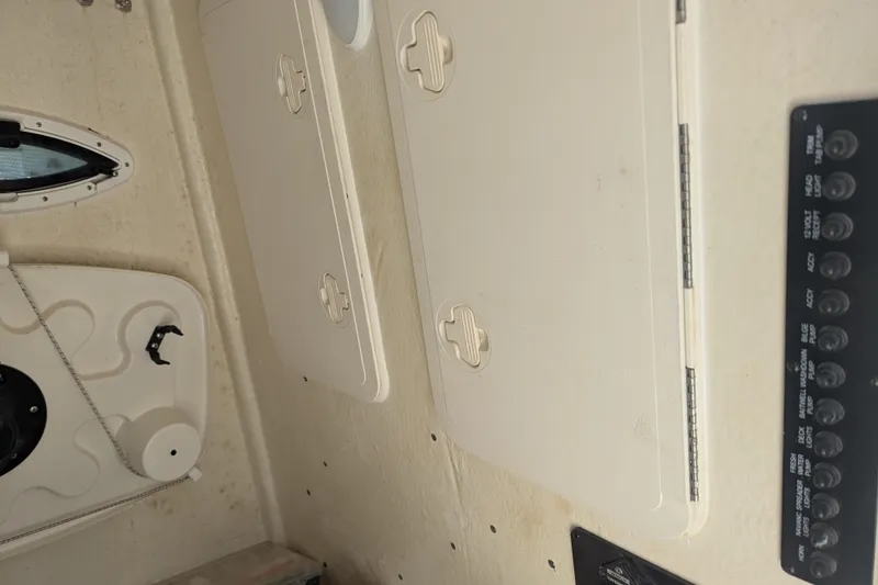 Slide: The Image of Interior view of 2023 Sailfish 290 CC boat with storage compartments and control panel. - 15