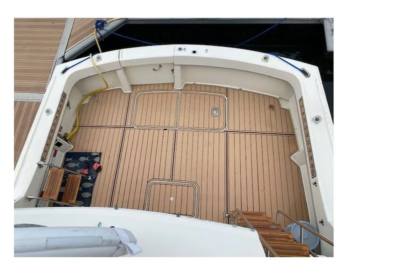 Slide: The Image of 1984 Hatteras 46 Convertible boat deck with teak flooring and dock view. - 32