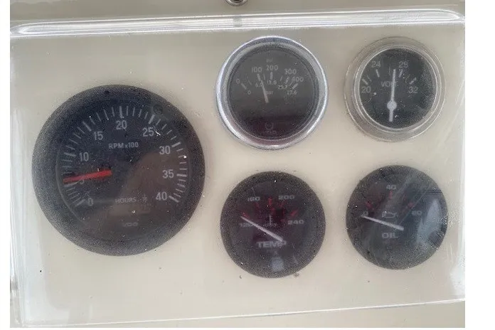 Slide: The Image of Dashboard gauges of a 1984 Hatteras 46 Convertible boat, displaying RPM, temperature, and oil pressure. - 21