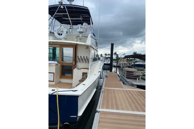 Slide: The Image of 1984 Hatteras 46 Convertible yacht docked at marina under cloudy sky. - 39