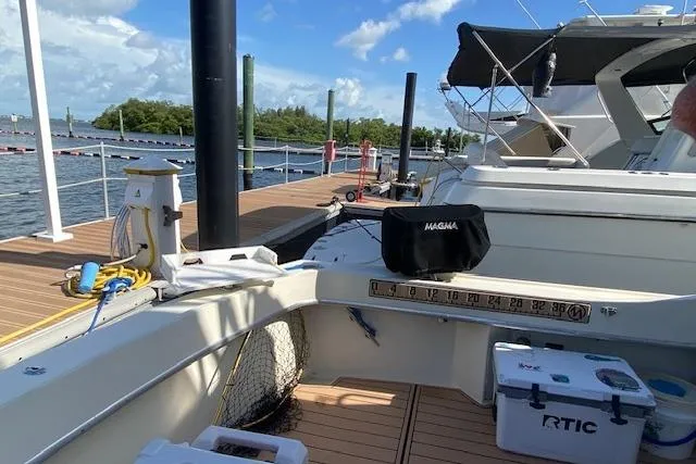 Slide: The Image of 1984 Hatteras 46 Convertible yacht docked, featuring fishing gear and coolers on deck. - 5