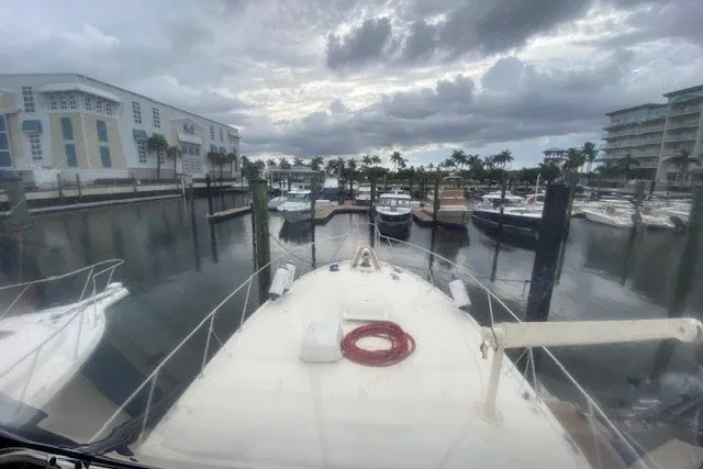 Slide: The Image of 1984 Hatteras 46 Convertible yacht docked at a marina under cloudy skies. - 35