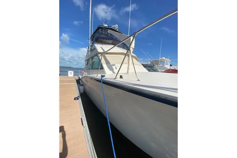 The Image of 1984 Hatteras 46 Convertible yacht docked under clear blue sky. - 3