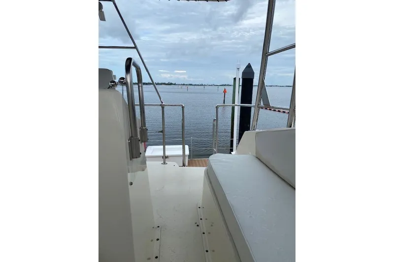 Slide: The Image of 1984 Hatteras 46 Convertible yacht deck overlooking calm waters and distant shoreline. - 30