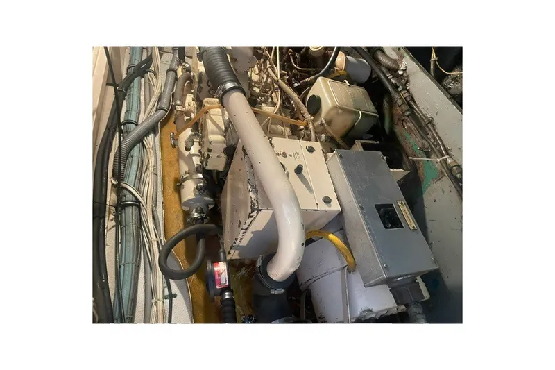 Slide: The Image of Engine room of 1984 Hatteras 46 Convertible boat, showcasing mechanical components and wiring. - 53