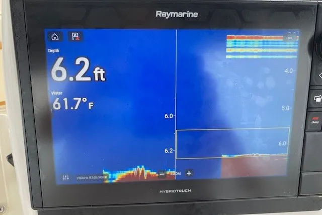 Slide: The Image of Raymarine display showing 6.2 ft depth and 61.7°F water temperature on Hatteras 46 Convertible. - 26